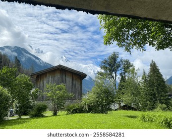 Charming Mountain Village with Snow-Capped Peaks and a Cloudy Sky - Powered by Shutterstock