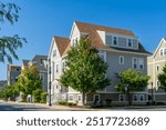 Charming multi-family house with shake-style siding and complex gable roofs in Brighton, Massachusetts, USA.