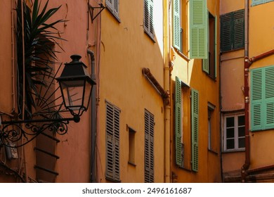 Charming narrow street with colorful buildings and vintage lanterns. Brightly painted shutters add character to the quaint alley bathed in warm sunlight, creating a picturesque urban scene. - Powered by Shutterstock