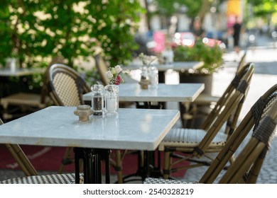 Charming outdoor café tables adorned with fresh flowers on a sunny day, inviting guests to relax and unwind - Powered by Shutterstock