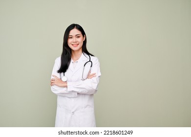 Charming and professional Asian female doctor in uniform with stethoscope arms crossed or arms folded, standing against grey studio background. - Powered by Shutterstock