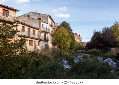 Charming Riverside Houses and Lush Vegetation Along a Small River in a Spanish Town - Powered by Shutterstock