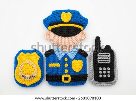 A charming set of knitted elements for a police officer costume, including a badge, uniform, and a walkie-talkie, perfect for creative projects.