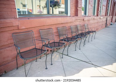 In A Charming Small Town, Inman, S.C., Cute Iron Chairs Sitting Out On The Sidewalk In Front Of A Restaurant With Brick Exterior.