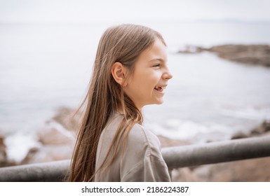 Charming Smiling Girl 10 Years Old Walks On The Beach. Portrait In Profile.