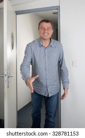 Charming and smiling Man opening a door and checking hands