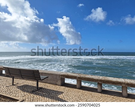 A charming square with a bench offering a scenic view of the Atlantic Ocean in Parede, Portugal. Ideal for travel, relaxation, and coastal city themes
