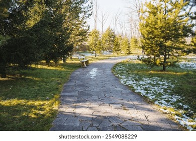 A charming stone path winds through a tranquil park filled with lush greenery, vibrant trees, and soft grass, offering visitors a serene natural experience for relaxation and peace of mind - Powered by Shutterstock