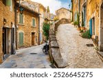 Charming street in quaint Menerbes village with colorful buildings and vibrant flowers. Village of Menerbes (Most Beautiful Village in France) in the Luberon mountains, France, Luberon, Vaucluse.