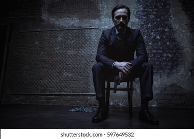 Charming Villain Sitting In Dark Room