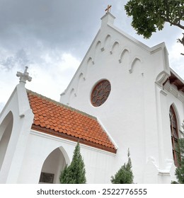 A charming white church building with a red brick roof and beautiful stained glass windows. - Powered by Shutterstock