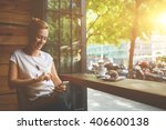 Charming woman with beautiful smile reading good news on mobile phone during rest in coffee shop, happy Caucasian female watching her photos on cell telephone while relaxing in cafe during free time 