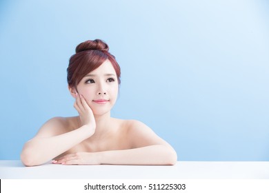 charming woman face smile and look somewhere close up while lying isolated on blue background, asian girl