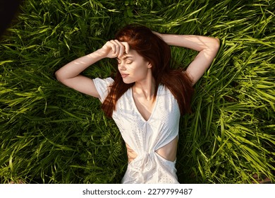 charming woman lies on the grass in white dress - Shutterstock ID 2279799487