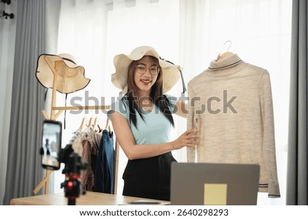 Charming woman presenting fashionable clothing in a stylish boutique setting, showcasing trendy apparel and accessories with modern technology