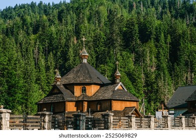 A charming wooden church with a distinct roof design stands amidst lush green trees under a bright blue sky. The serene location invites tranquility and reflection. - Powered by Shutterstock