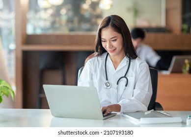 Charming young Asian doctor woman printing laptop computer on work table. - Powered by Shutterstock