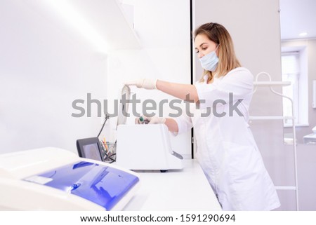Charming young female scientist stacks analysis in a climate control chamber in a laboratory for further research. Concept of creating vaccines and new antiviral drugs. Healthcare and Genetic Research