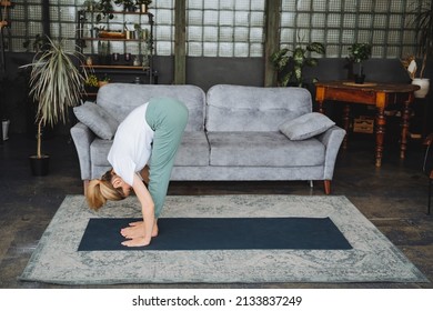 A charming young girl does stretching on mat. Girl stands in Uttanasana.Standing Forward Bend Pose,Good stretching and flexibility of the body. High quality photo