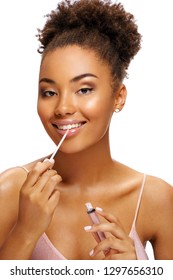 Charming Young Girl Using Lip Gloss. Photo Of Smiling African American Girl On White Background. Beauty Concept