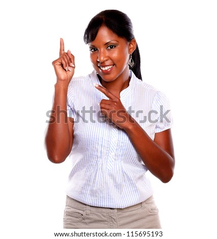 Charming young woman pointing up while is looking at you against white background