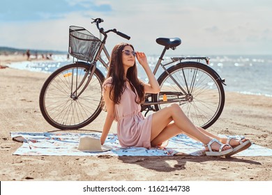 Charming young woman in sunglasses and dress enjoy vacation on the beach. - Powered by Shutterstock