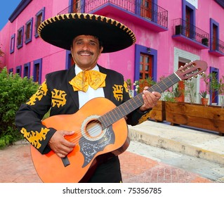 Charro Mariachi Singer Playing Guitar In Mexico Houses Background