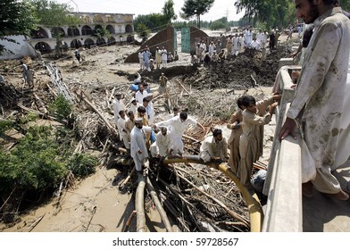 CHARSADDA, PAKISTAN - AUG 3: Flood affected people walk on cables to reach their destination on August 3, 2010 in Charsadda. The Khayali Bridge was destroyed by flood waters.
