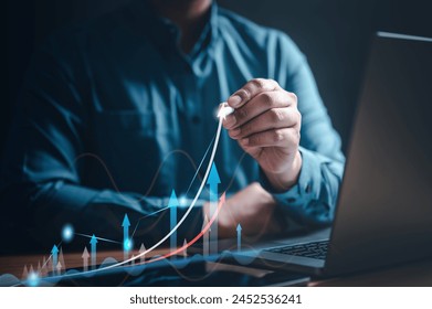 chart, diagram, graph, index, invest, marketing, growth, analytics, opportunity, analysis. A man is drawing a graph on a laptop, with a line is pointing upwards. The graph is showing a positive trend. - Powered by Shutterstock