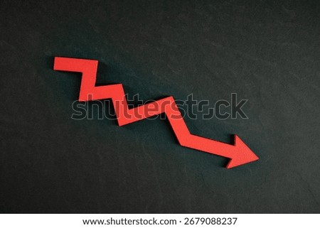 Chart with red down arrow isolated on black background. Falling growth in business