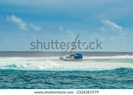 Charter or private sailing yacht run aground on a reef in French Polynesia