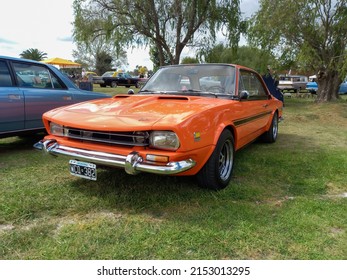 CHASCOMUS, ARGENTINA - Apr 10, 2022: Old IKA Renault Torino Lutteral Comahue Coupe 1968 - 1978 In The Countryside  Nature, Grass, Trees  Classic Orange Sport Compact Car  Copyspace