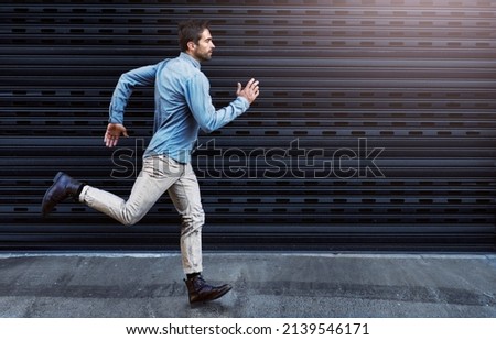 Chase after your dreams. Shot of a handsome young man running in the city.