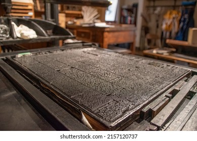 A chase, a rectangular block used for placing letters in letterpress printing (also known as relief or typography printing), is set up with a full page of news print.