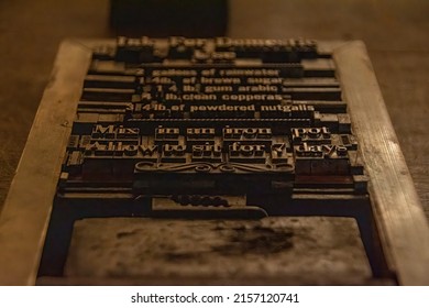 A chase, a rectangular block used for placing letters in letterpress printing (also known as relief or typography printing), is set up with a recipe for ink. Image flipped for readability.