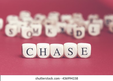 Chase word written wood cube and red background