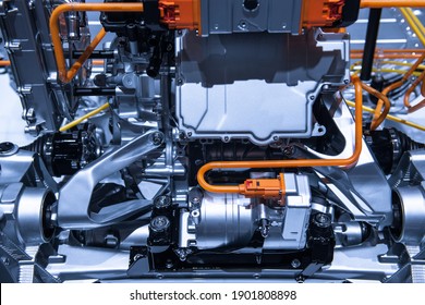 Chassis of the electric car with powertrain and power connections closeup. Blue toned. EV car drivetrain at maintenance
