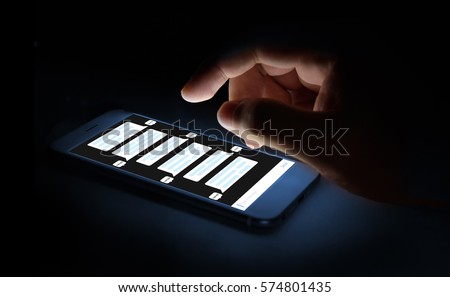 Chat bot , deep learning , artificial intelligence concept . Finger point to mobile phone with chatbot application. Blue tone