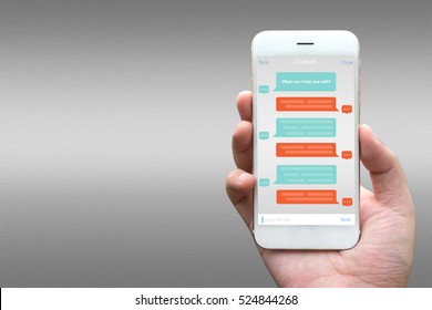 Chat Bot And Future Marketing Concept. Businessman Hand Holding White Phone With Chatbot Application With Gray Aluminium Background.