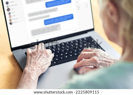 Chat messages in laptop of an old woman. Love fraud scam of catfish. Elder person in online conversation with family. Grandma group messaging. Communication in social media. Customer support chatbot.