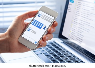 Chatbot conversation on smartphone screen app interface with artificial intelligence technology providing virtual assistant customer support and information, person hand holding mobile phone