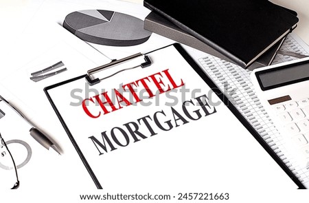 CHATTEL MORTGAGE text on a clipboard on chart with notebook and calculator. 