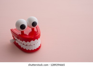 Chattering teeth toy wind up moving on pink background. Funny,comedy, relax time or dental care concept
