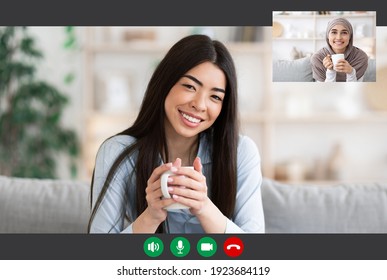 Chatting With Friend. Portrait Screen View Of Cheerful Young Asian Lady Making Online Video Call With Muslim Woman In Hijab, Smiling Millennial Females Having Virtual Meeting, Drinking Coffee