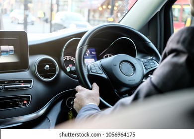 Chauffeur Hand On Luxury Steering With Function Control And Man In Suite As Foreground