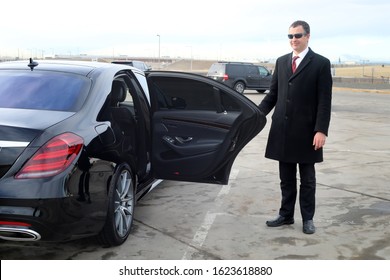 Chauffeur Holds A Rear Passenger Door Open