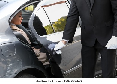 Chauffeur Opening Door Of Luxury Car