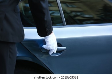 Chauffeur Opening Door Of Luxury Car