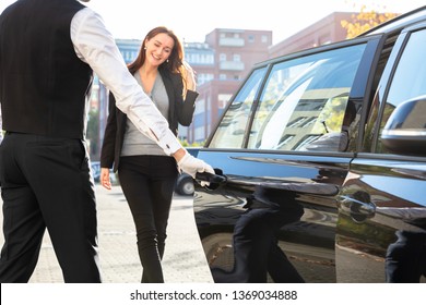 Chauffeur Opening Private Car Door For Businesswoman
