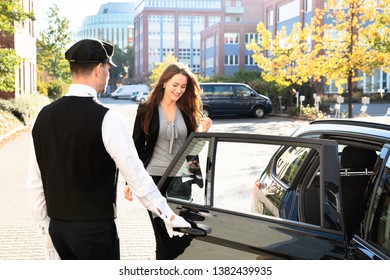 Chauffeur Opening Private Car Door For Businesswoman
